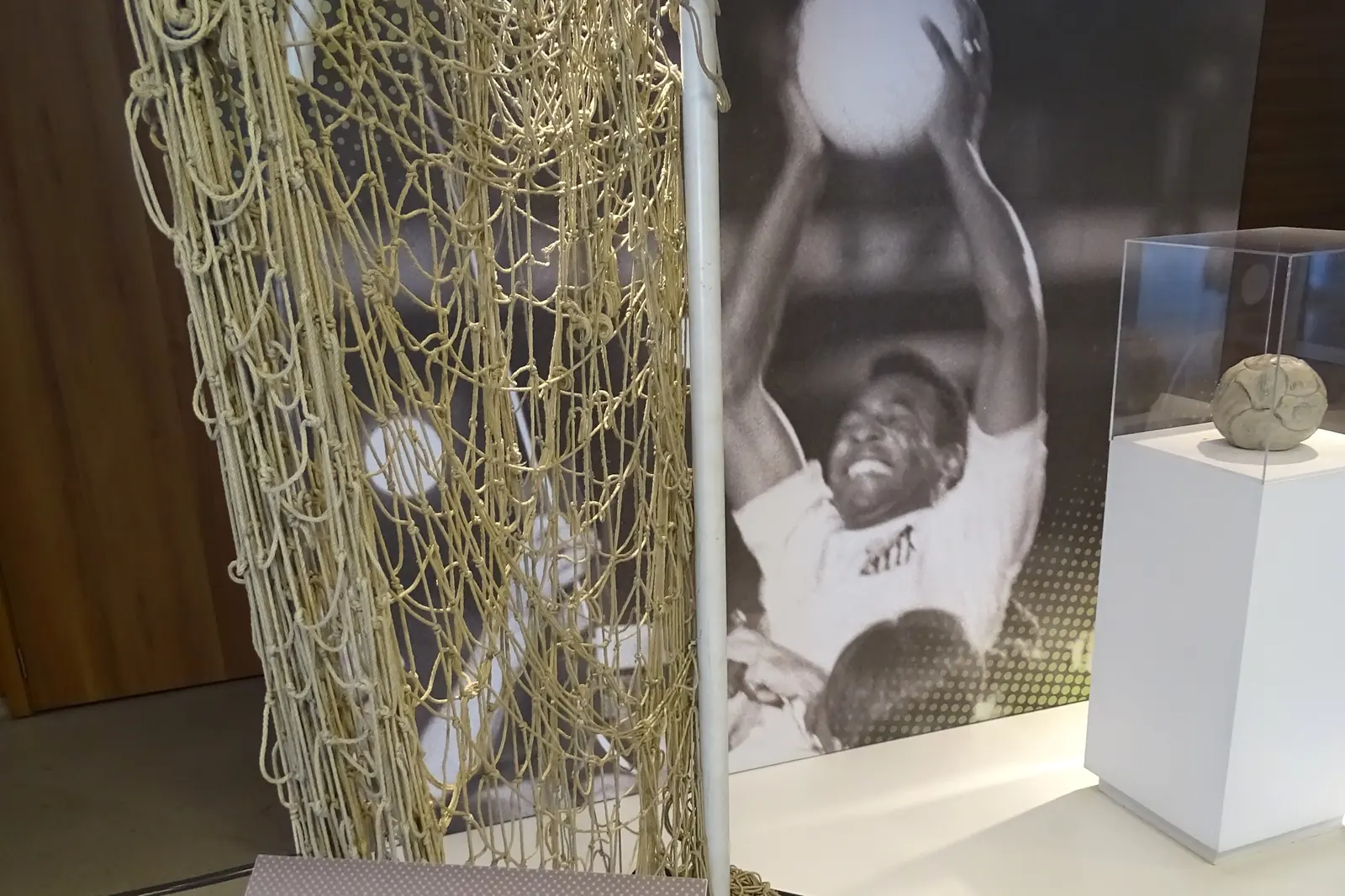 A museum display case about Pelé, with a goal net and a photograph of the player beside an information panel